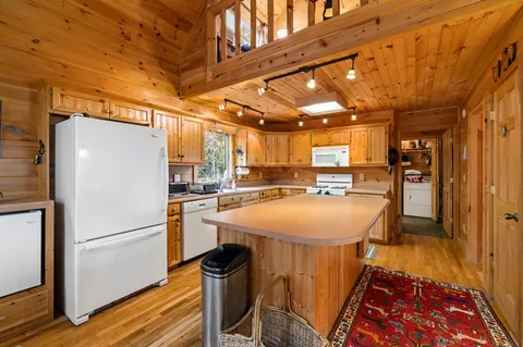 a kitchen with stainless steel appliances granite countertop a refrigerator a sink and a stove