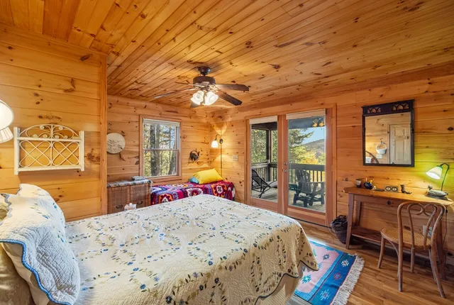 a bed room with a bed a chair and next to a window