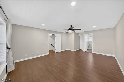 a room with wooden floor and windows