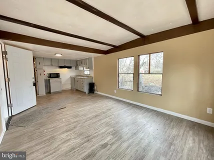 a large white kitchen with wooden floors and white walls