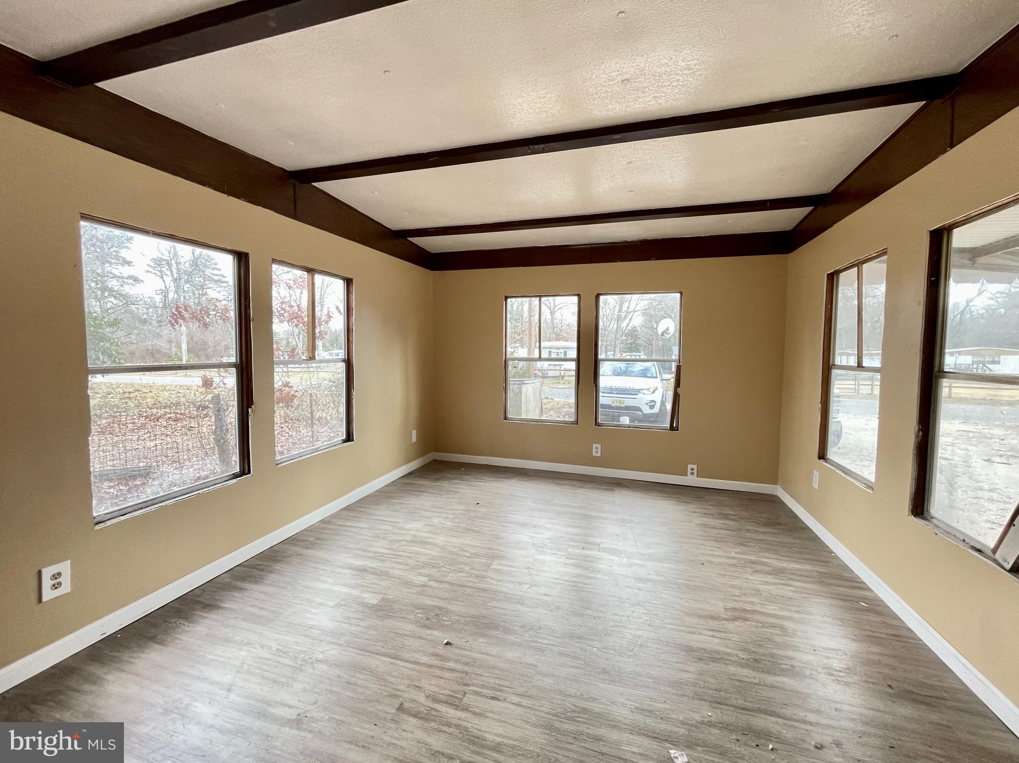 541 Fern Road Millville, NJ 08332 - Photo 4 of 15 an empty room with wooden floor and windows