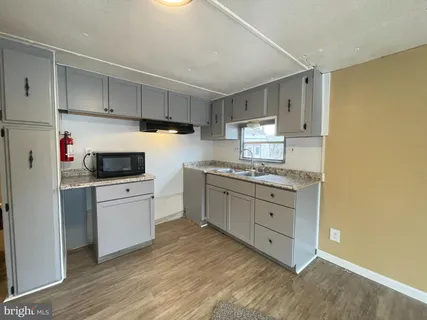a kitchen with granite countertop white cabinets and white appliances