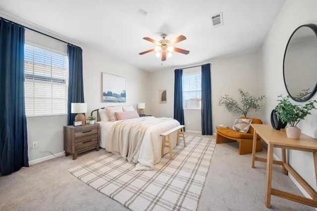 a spacious bedroom with a bed and a chandelier