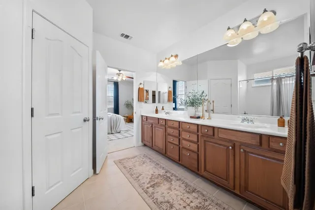 a spacious bathroom with a double vanity sink and a mirror
