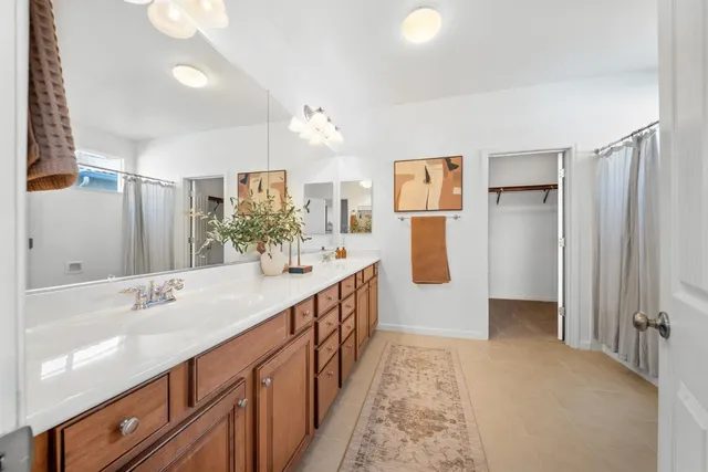 a bathroom with sink shower and mirror
