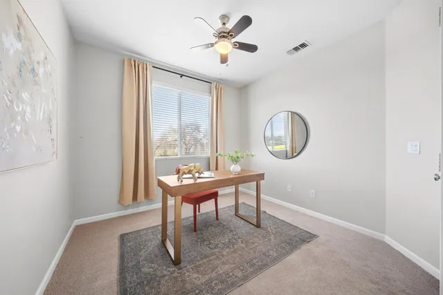 a workspace with wooden floor and a chandelier fan