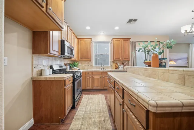 a kitchen with stainless steel appliances granite countertop a lot of counter space and a sink