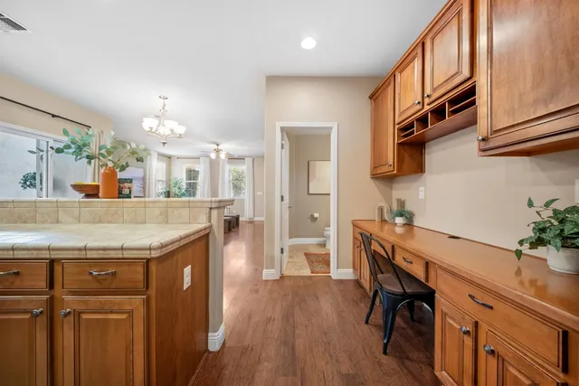 a kitchen with stainless steel appliances kitchen island granite countertop a table chairs in it and wooden floors