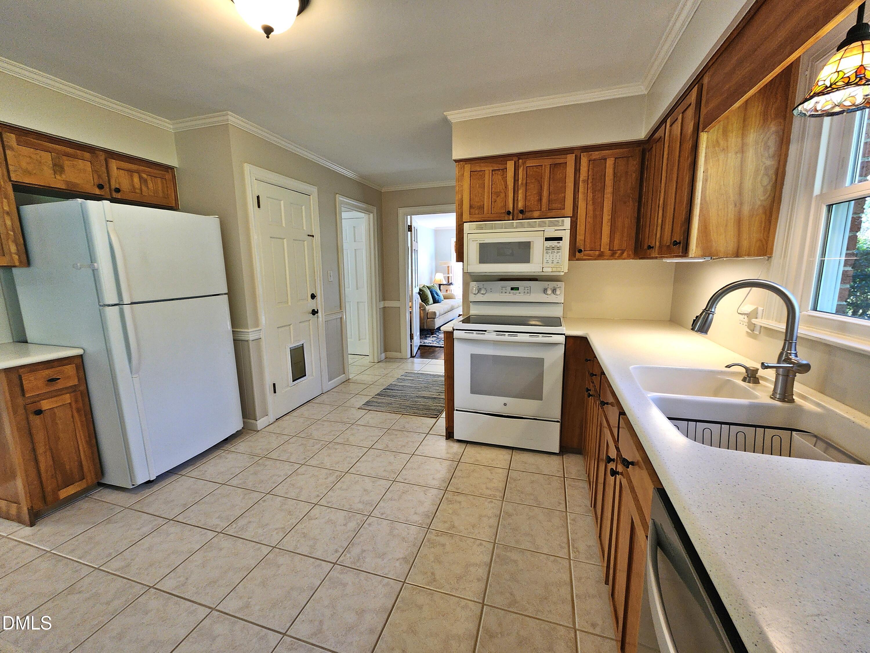 4704 Oak Park Road Raleigh, NC 27612 - Photo 24 of 62 a kitchen with a refrigerator sink and cabinets