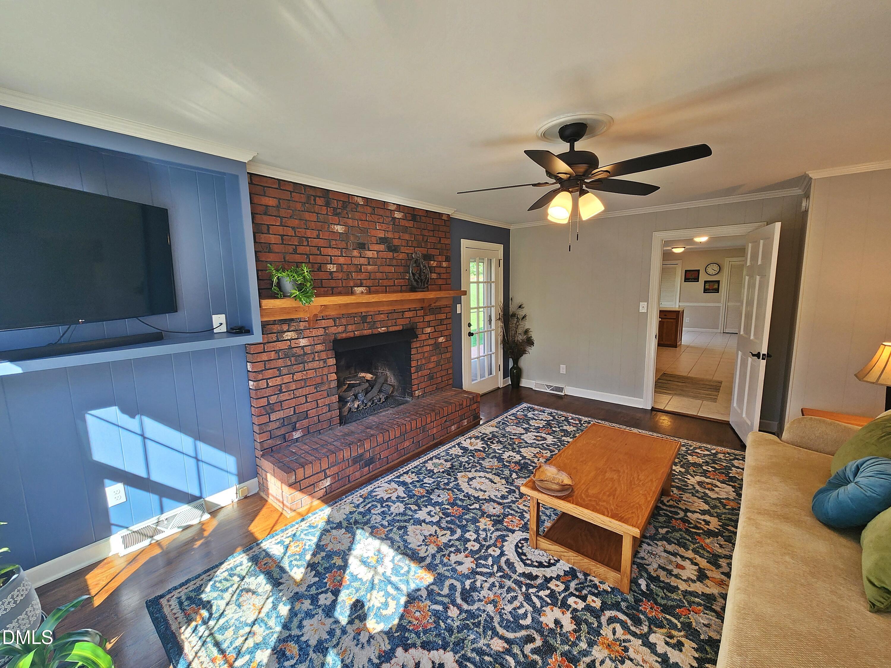 4704 Oak Park Road Raleigh, NC 27612 - Photo 33 of 62 a living room with furniture a flat screen tv and a fireplace