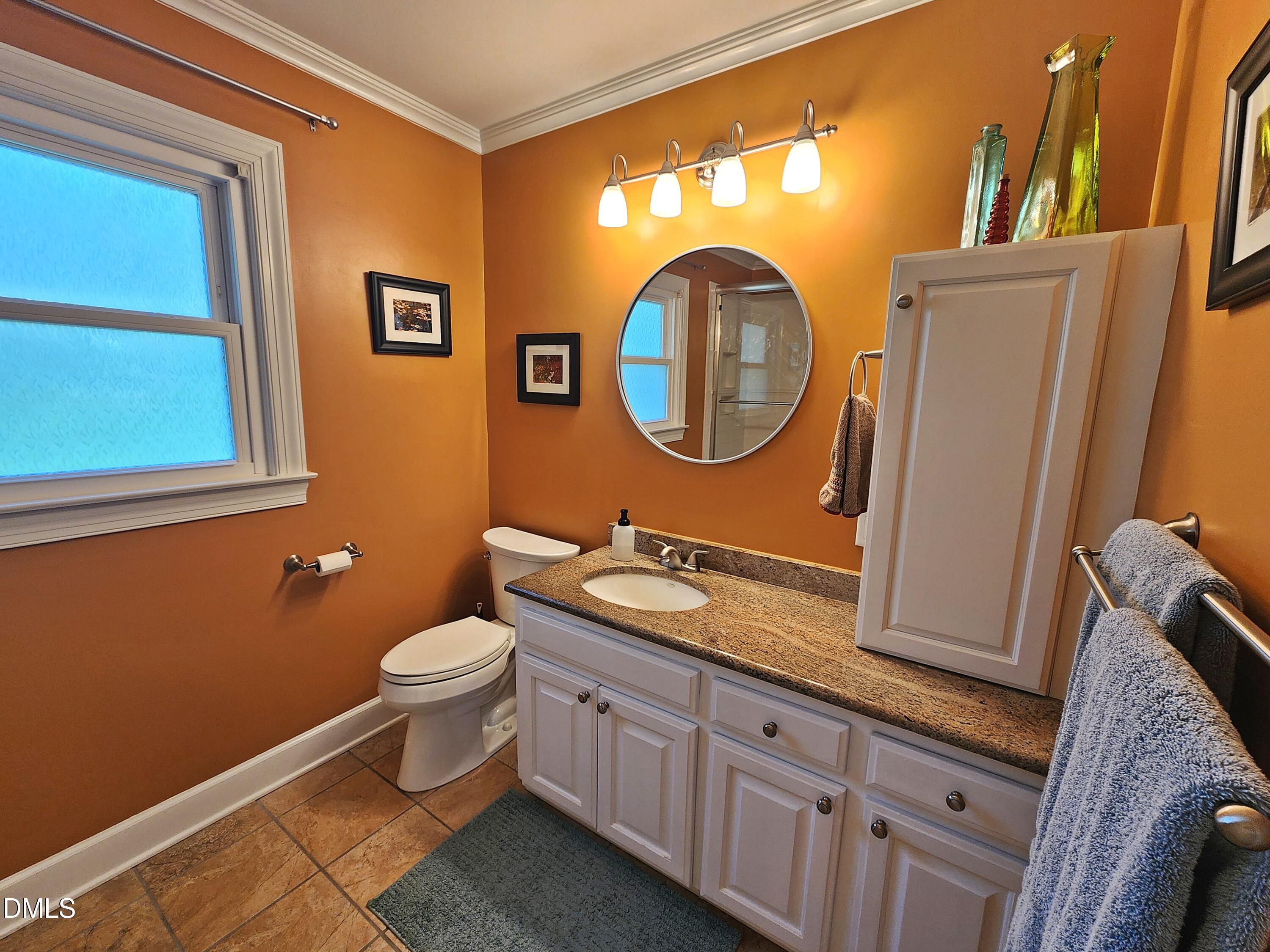 4704 Oak Park Road Raleigh, NC 27612 - Photo 44 of 62 a bathroom with a toilet a sink and a mirror