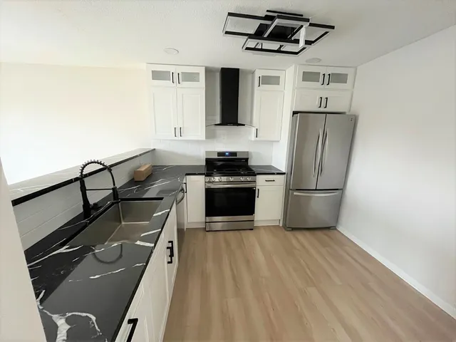 a kitchen with granite countertop a stove and a refrigerator