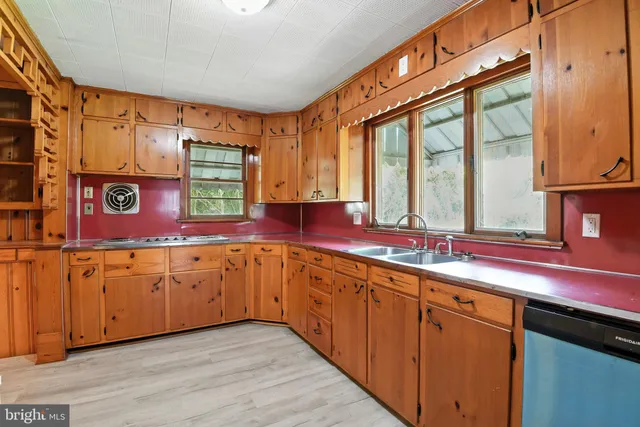 a kitchen with stainless steel appliances sink cabinets and wooden floor