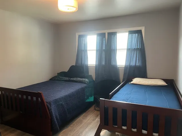 a bedroom with a bed and a flat tv screen on a dresser