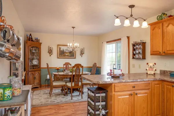 a kitchen with stainless steel appliances granite countertop a stove a sink dishwasher and a refrigerator with wooden floor