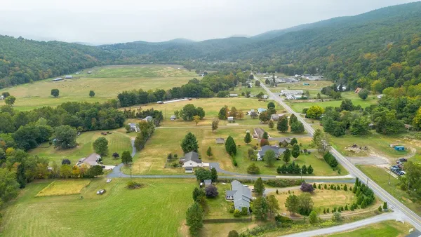 a view of a house with a yard and large tree