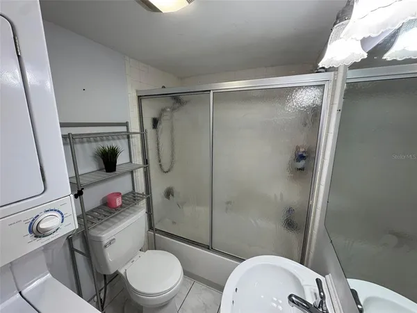 a white toilet sitting next to a bathroom sink and shower