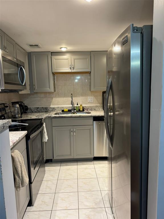 912 Lake Destiny Road, Unit G Altamonte Springs, FL 32714 - Photo 18 of 24 a kitchen with stainless steel appliances granite countertop a sink a stove and a refrigerator