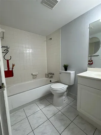 a white toilet sitting next to a bathroom sink and vanity