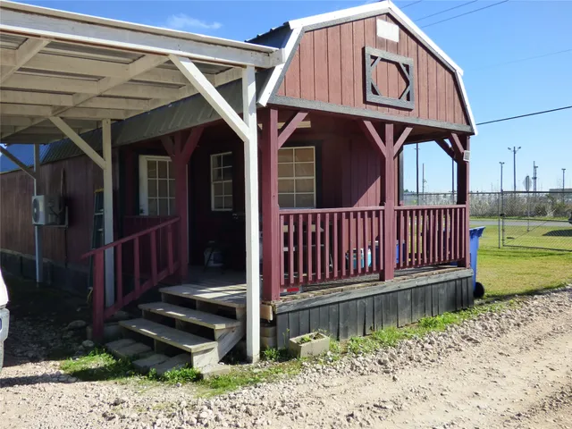 a view of a small house with wooden fence