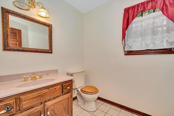 a bathroom with a toilet sink vanity and mirror