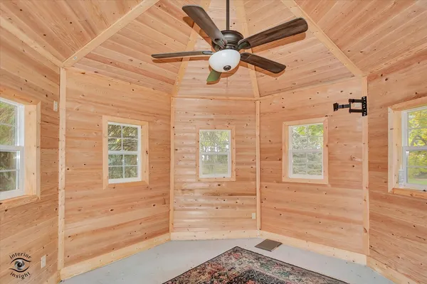 a front view of a house with a yard and large tree