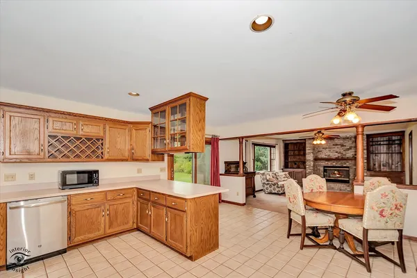 a kitchen with a refrigerator and table chairs
