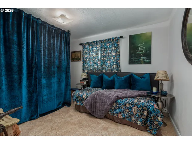 a bedroom with a bed mirror and window
