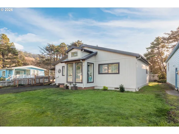 a view of a house with a big yard and large trees