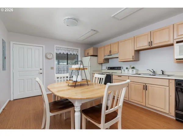 a kitchen with stainless steel appliances granite countertop a table chairs and a refrigerator