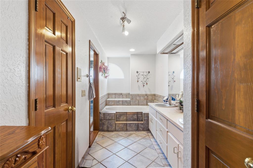 215 Santa Rosa Drive Winter Haven, FL 33884 - Photo 21 of 29 a bathroom with a double vanity sink a mirror a bathtub and shower