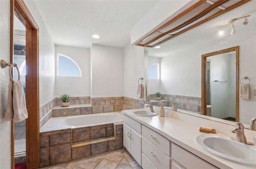 215 Santa Rosa Drive Winter Haven, FL 33884 - Photo 22 of 29 a bathroom with a double vanity sink a mirror and a bathtub