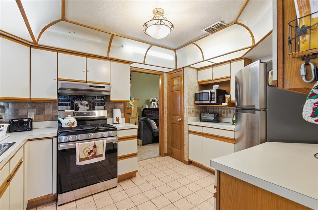 215 Santa Rosa Drive Winter Haven, FL 33884 - Photo 6 of 29 a kitchen with stainless steel appliances granite countertop a refrigerator and a stove top oven