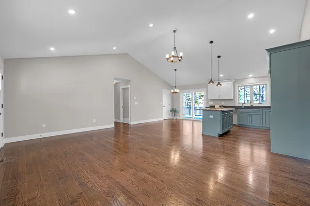 a view of a kitchen with a sink wooden cabinets and a window