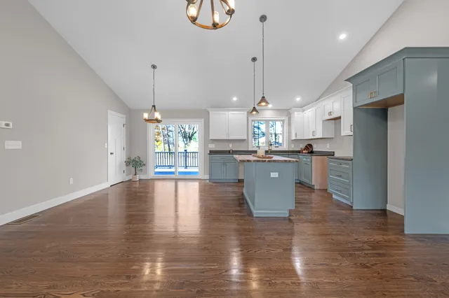 a kitchen with stainless steel appliances granite countertop a sink a stove and a refrigerator