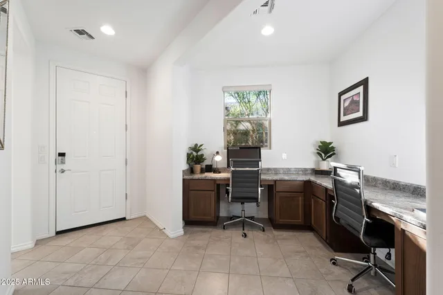 a view of a workspace with furniture and a window