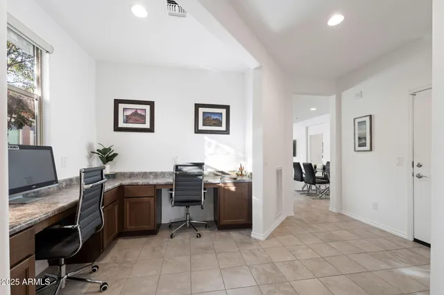 a view of a workspace with furniture and a window