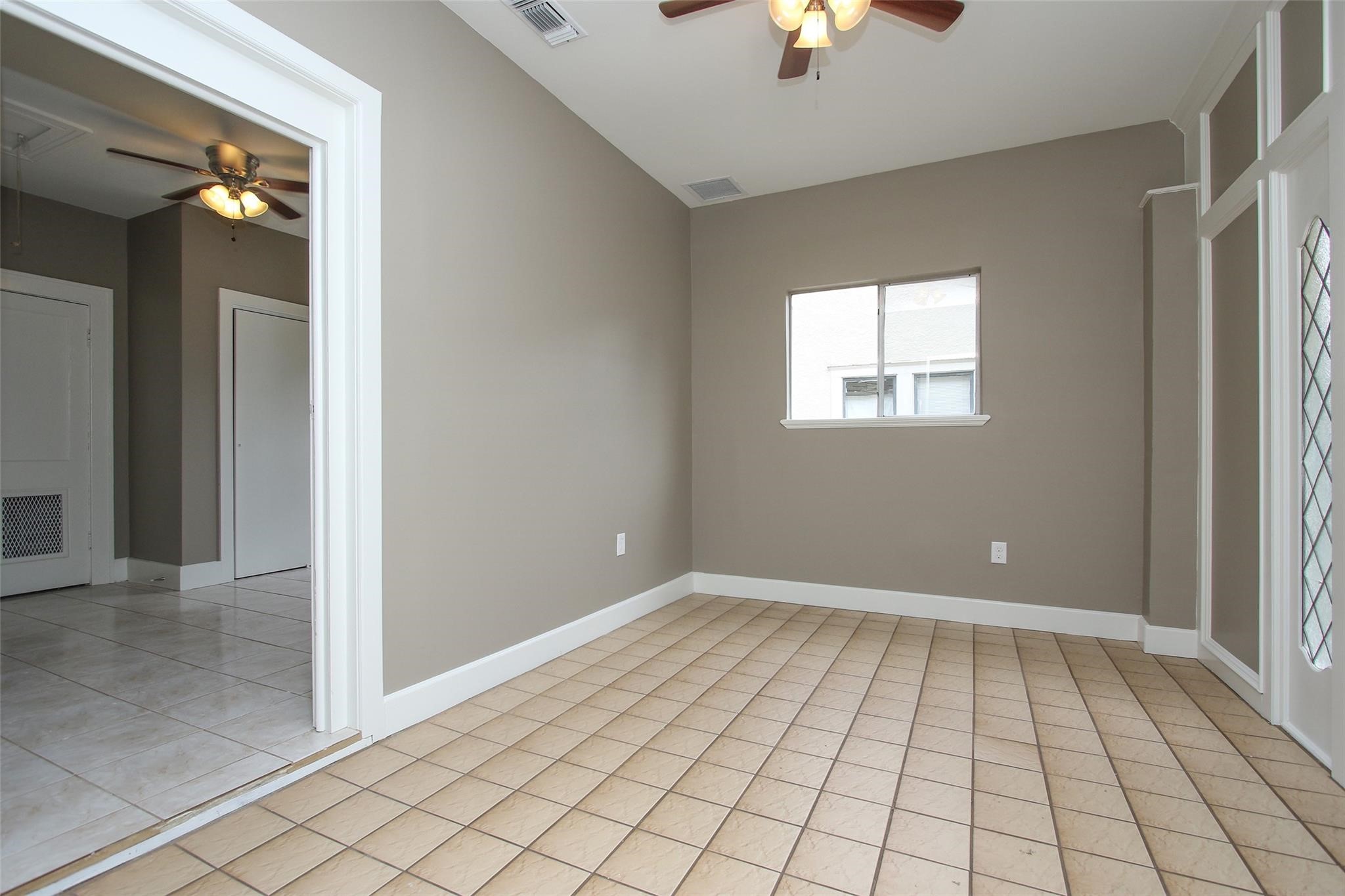 1127 Walling Street Houston, TX 77009 - Photo 21 of 23 en empty room with windows and chandelier fan