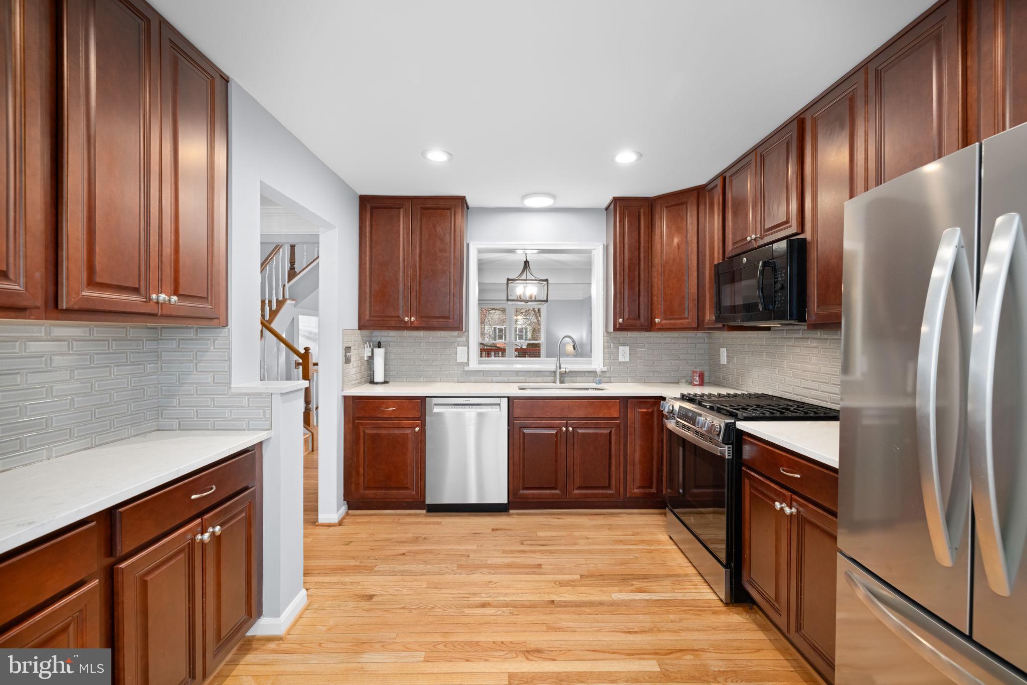 43861 Laburnum Square Ashburn, VA 20147 - Photo 11 of 46 a kitchen with stainless steel appliances granite countertop a refrigerator stove microwave and sink