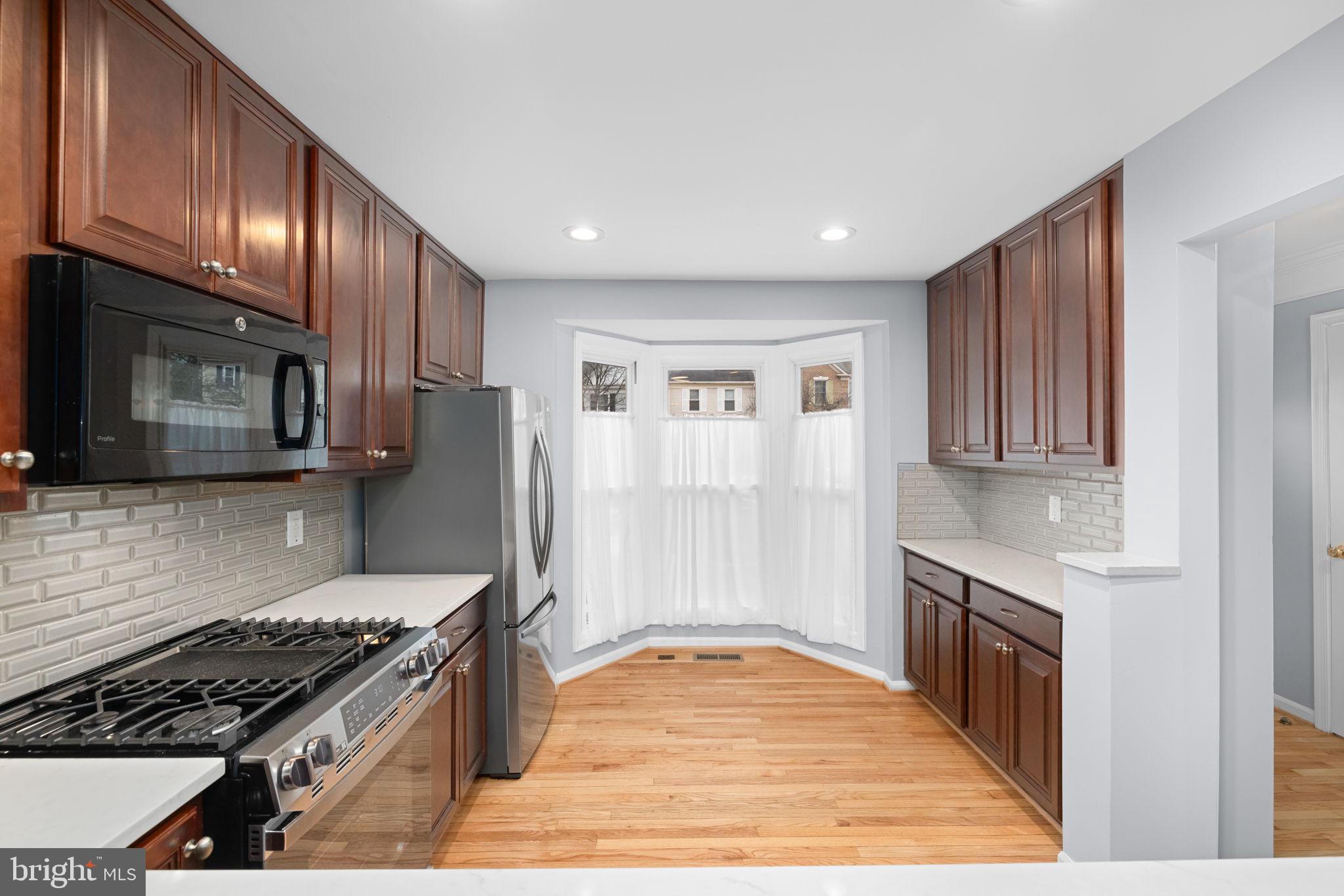 43861 Laburnum Square Ashburn, VA 20147 - Photo 12 of 46 a kitchen with granite countertop stainless steel appliances and wooden cabinets