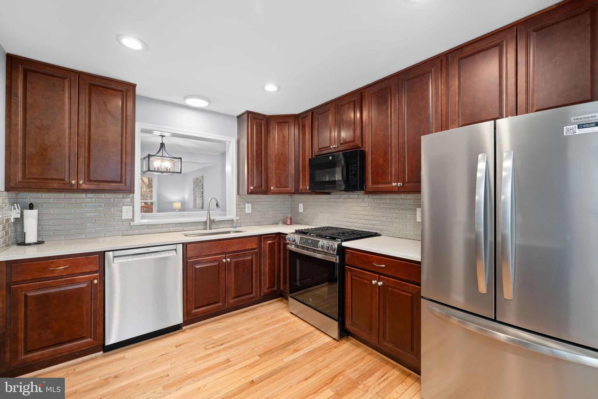 43861 Laburnum Square Ashburn, VA 20147 - Photo 14 of 46 a kitchen with stainless steel appliances granite countertop wooden cabinets a stove top oven a sink and dishwasher