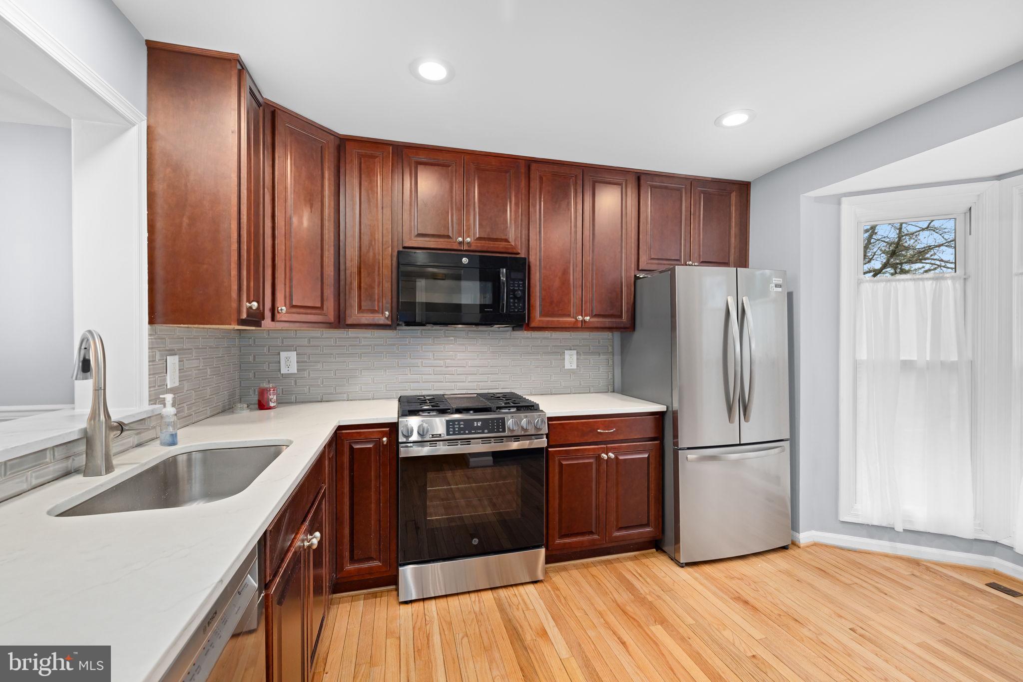 43861 Laburnum Square Ashburn, VA 20147 - Photo 15 of 46 a kitchen with wooden cabinets and stainless steel appliances