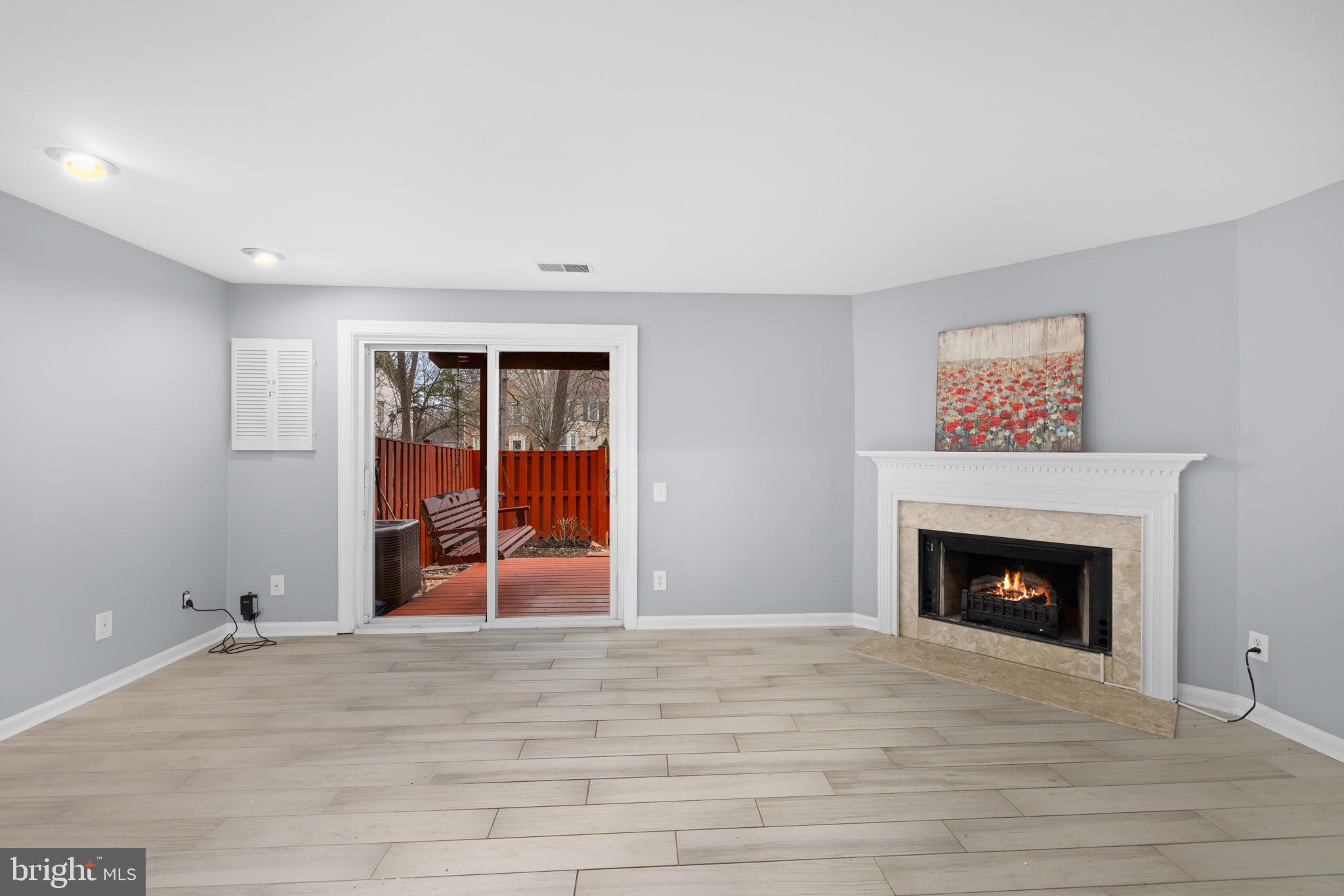 43861 Laburnum Square Ashburn, VA 20147 - Photo 35 of 46 a view of an empty room with wooden floor fireplace and a window
