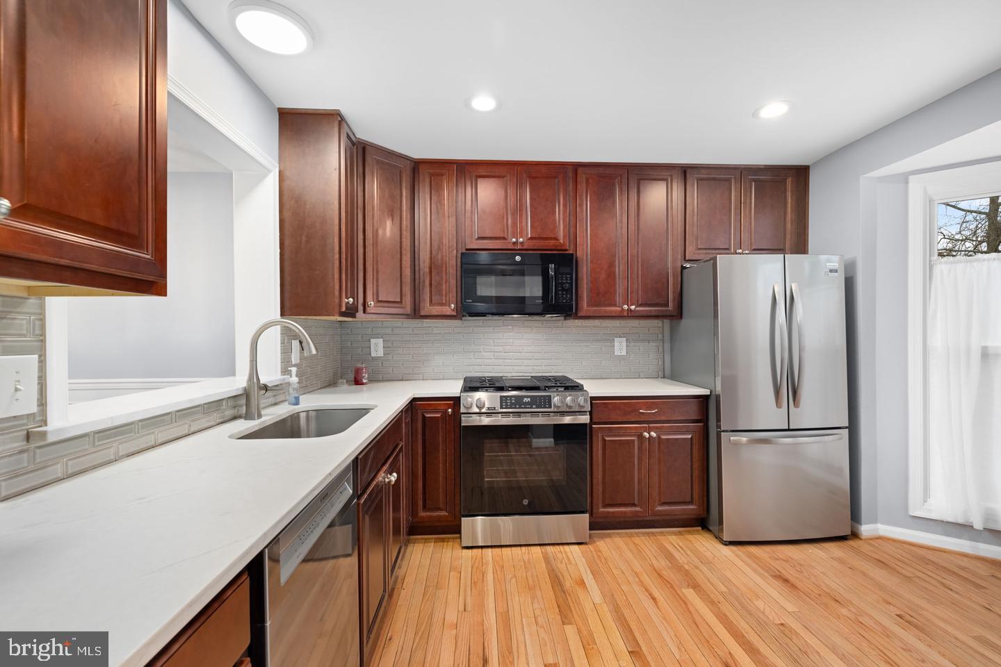 43861 Laburnum Square Ashburn, VA 20147 - Photo 4 of 46 a kitchen with wooden cabinets and stainless steel appliances
