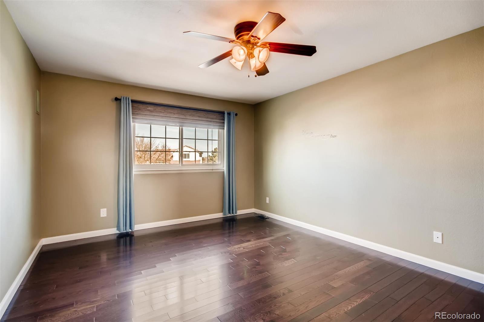 1518 Spring Water Way Highlands Ranch, CO 80129 - Photo 14 of 26 an empty room with wooden floor and windows