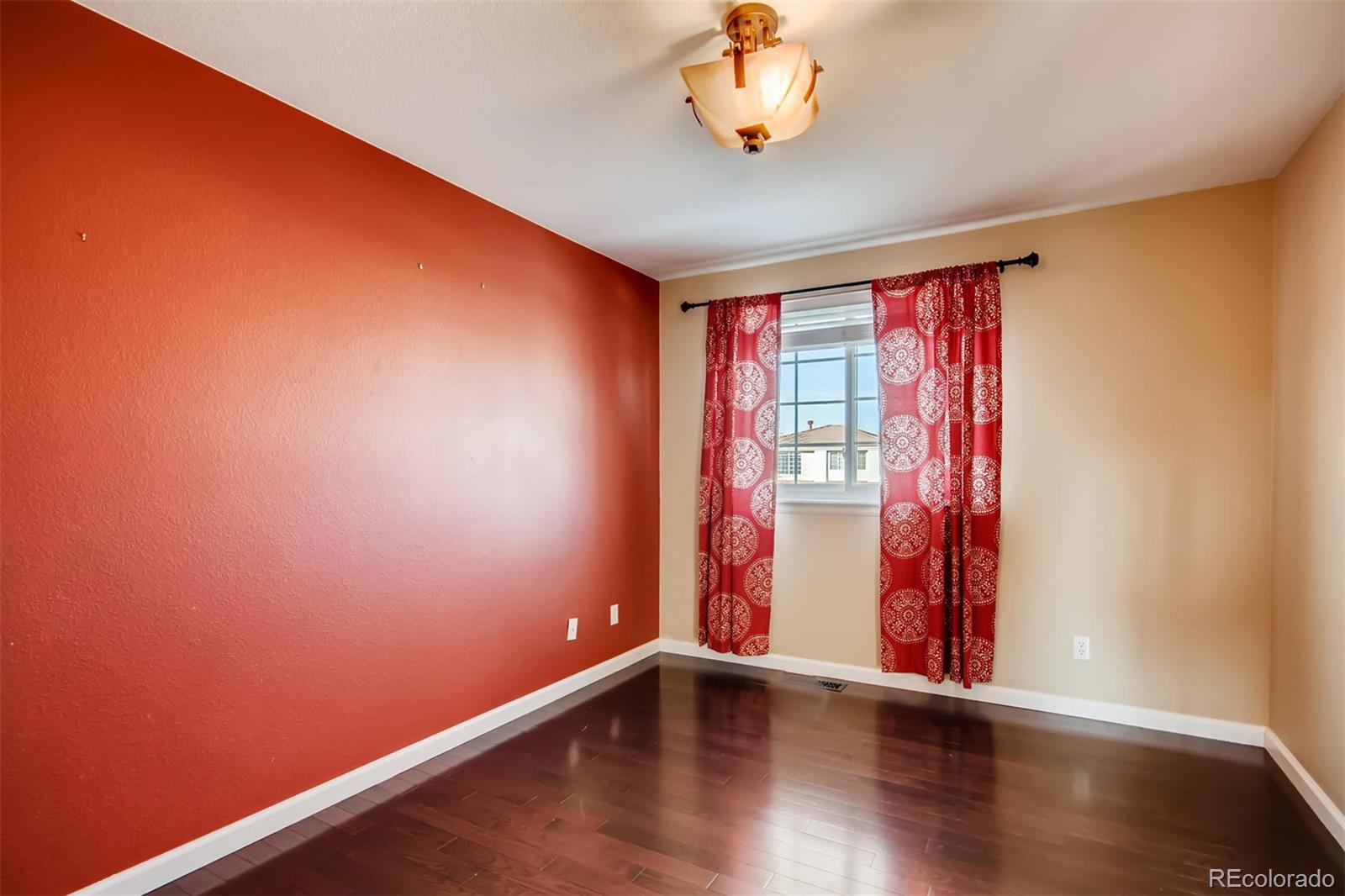1518 Spring Water Way Highlands Ranch, CO 80129 - Photo 18 of 26 a view of an empty room with wooden floor and a window
