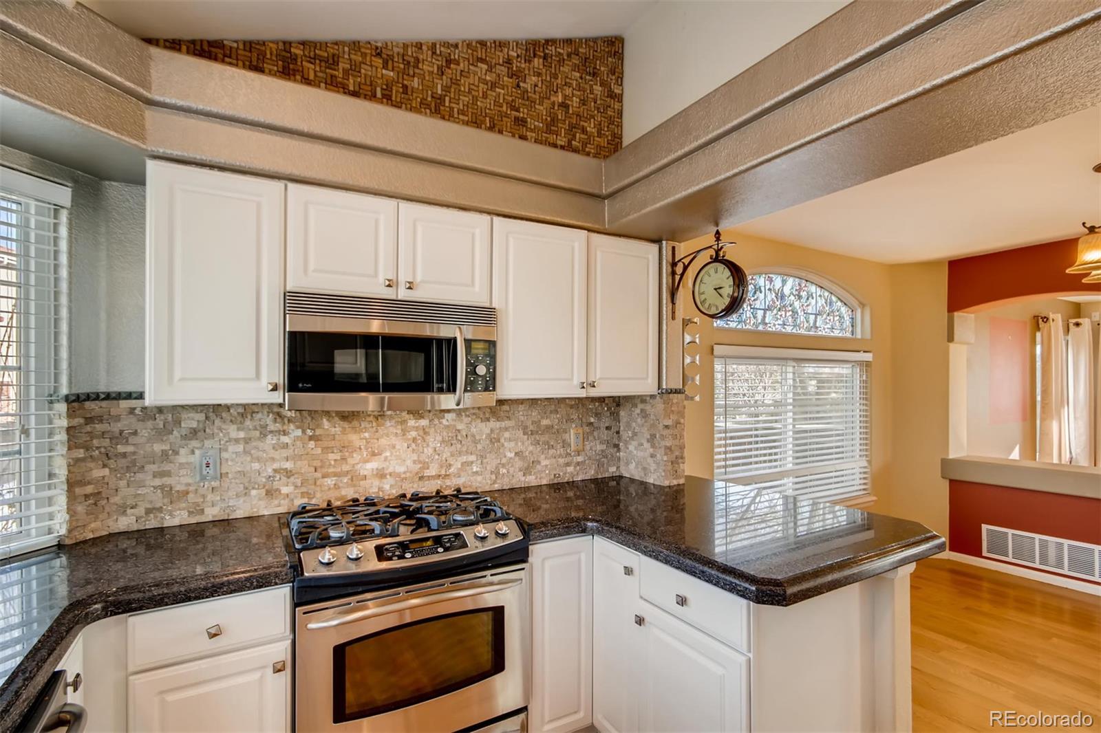1518 Spring Water Way Highlands Ranch, CO 80129 - Photo 10 of 26 a kitchen with granite countertop a stove sink and cabinets