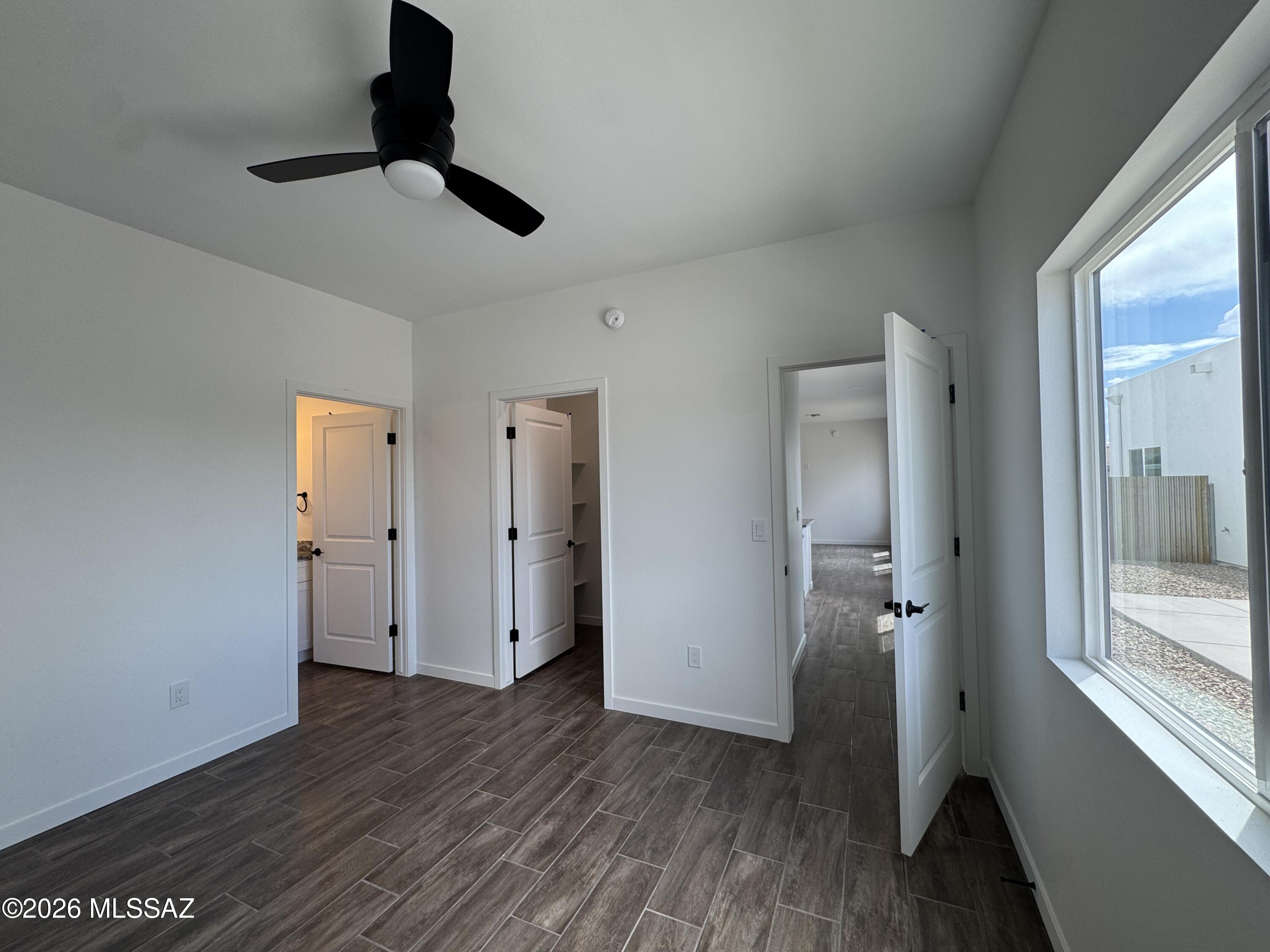 2130 North Ralph Avenue, Unit 1 Tucson, AZ 85712 - Photo 7 of 11 a view of a room with wooden floor a ceiling fan and windows