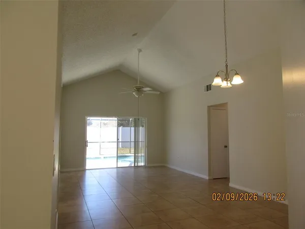 a view of a room with wooden floor and chandelier