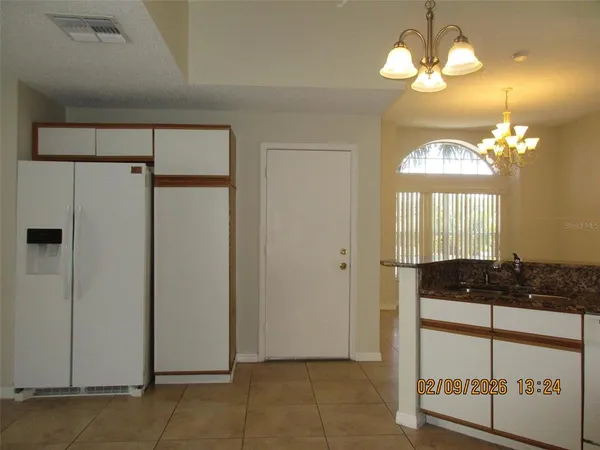 a kitchen with a refrigerator a stove a mirror and cabinets